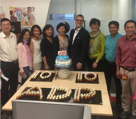 ADP China associates standing around a 10-year anniversary cake