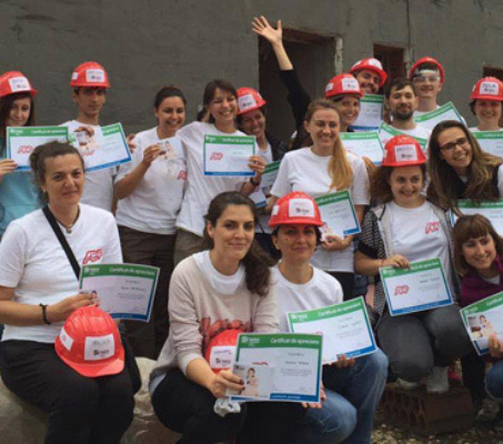 group of ADP associates wearing white T-shirts and red construction hardhats