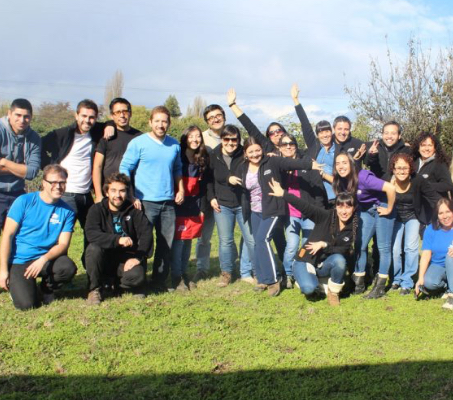 large group of ADP associates standing and kneeling on the grass at a park