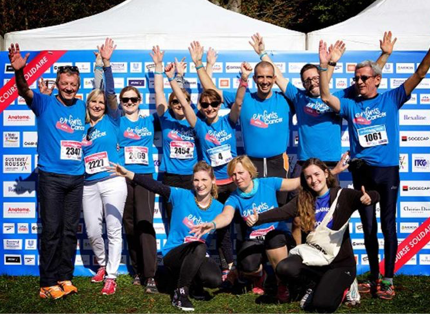 group of ADP associates in blue T-shirts waving their hands in the air; participating in 'enfants sans cancer' event