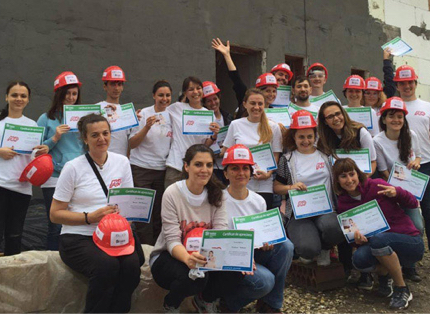 group of ADP associates wearing white T-shirts and red hardhats