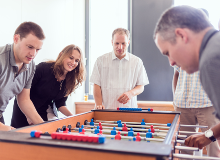 ADP associates playing Foosball.