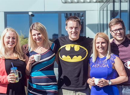 A small team of associates embracing one another for a picture.