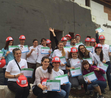 group of ADP associates wearing white T-shirts and red construction hardhats