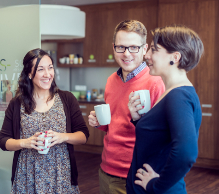 Four ADP associates holding coffee mugs