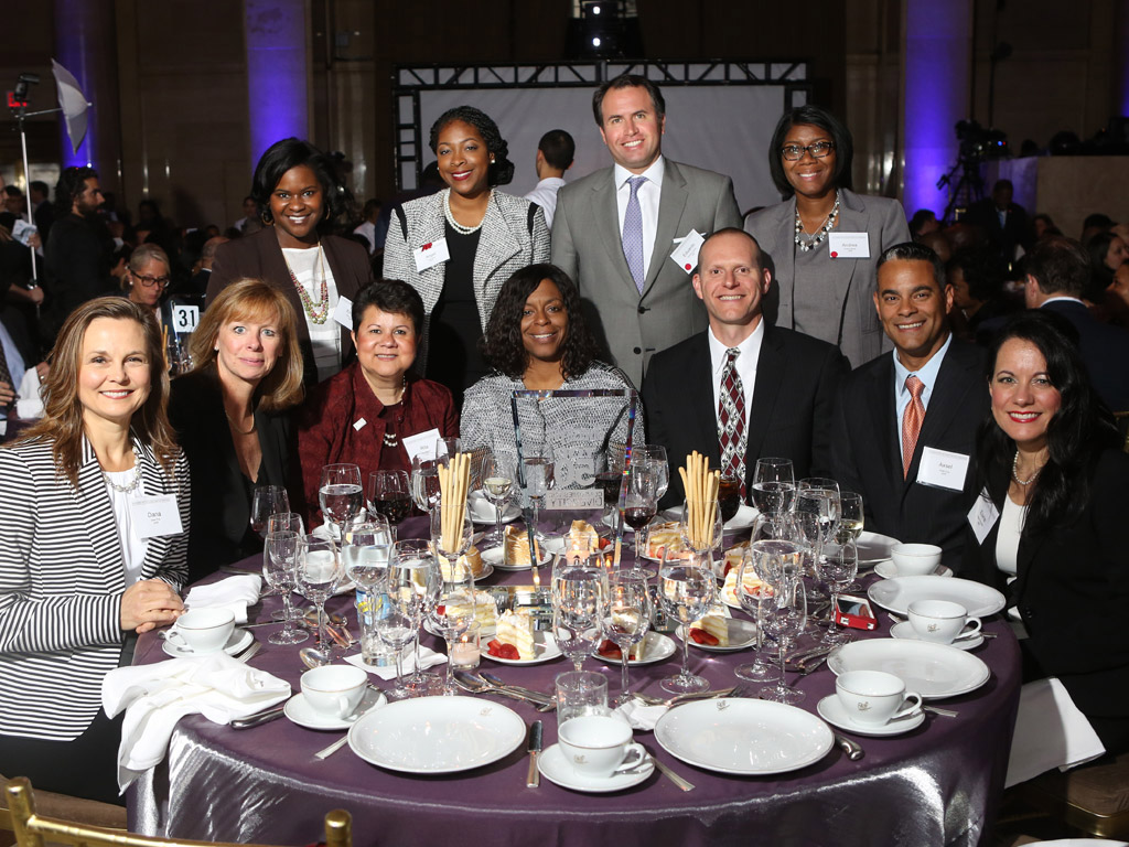 ADP associates seated and standing around an awards banquet table.