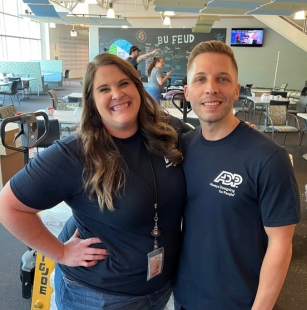 woman and man wearing navy blue ADP shirts, standing together for photo