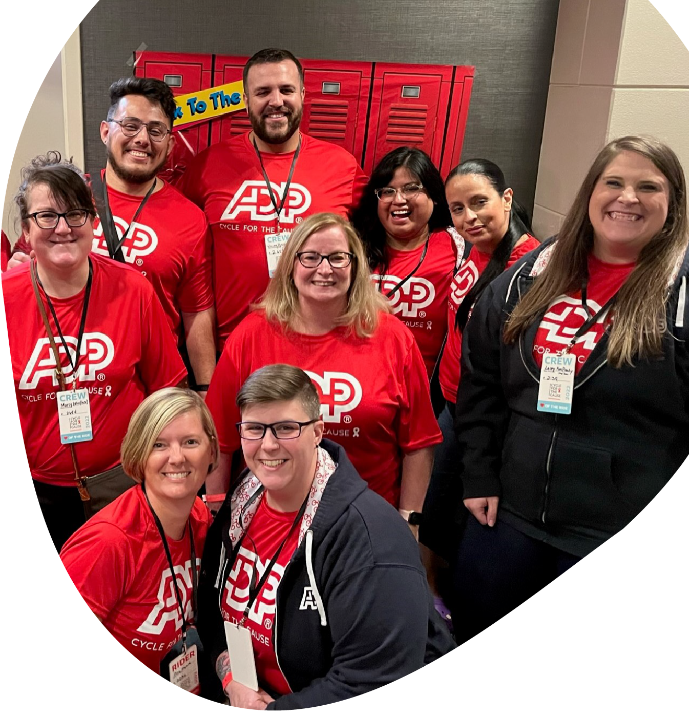 nine people wearing red ADP t-shirts smiling into the camera